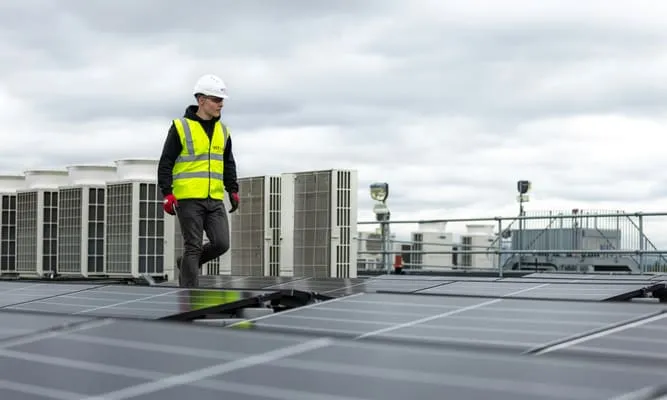 Technician inspecting rooftop HVAC units
